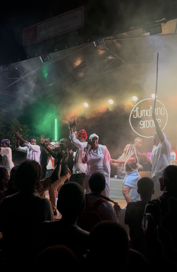 Tanssijoita lavalla, katsojia lavan edessä selät kameraan päin