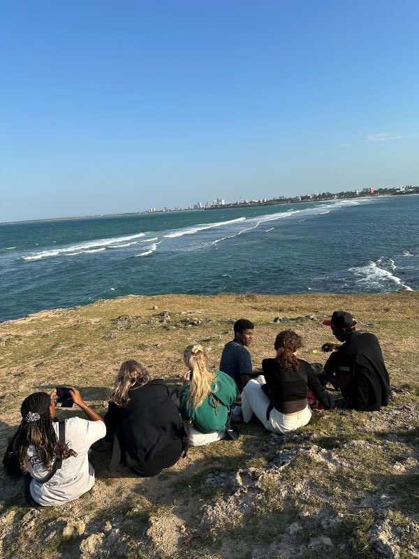 Ihmisiä istumassa rannalla